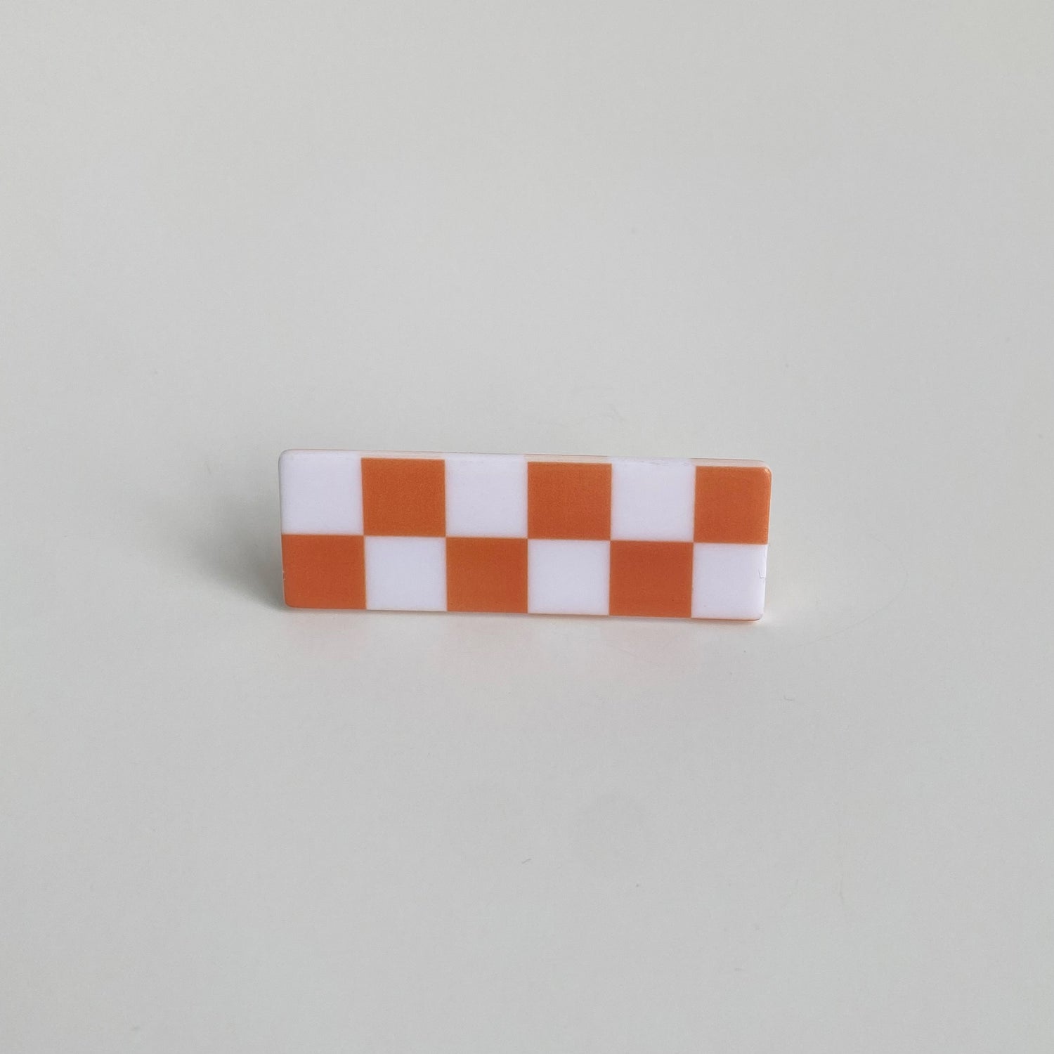 Checkered hairpin in orange checkered rectangle