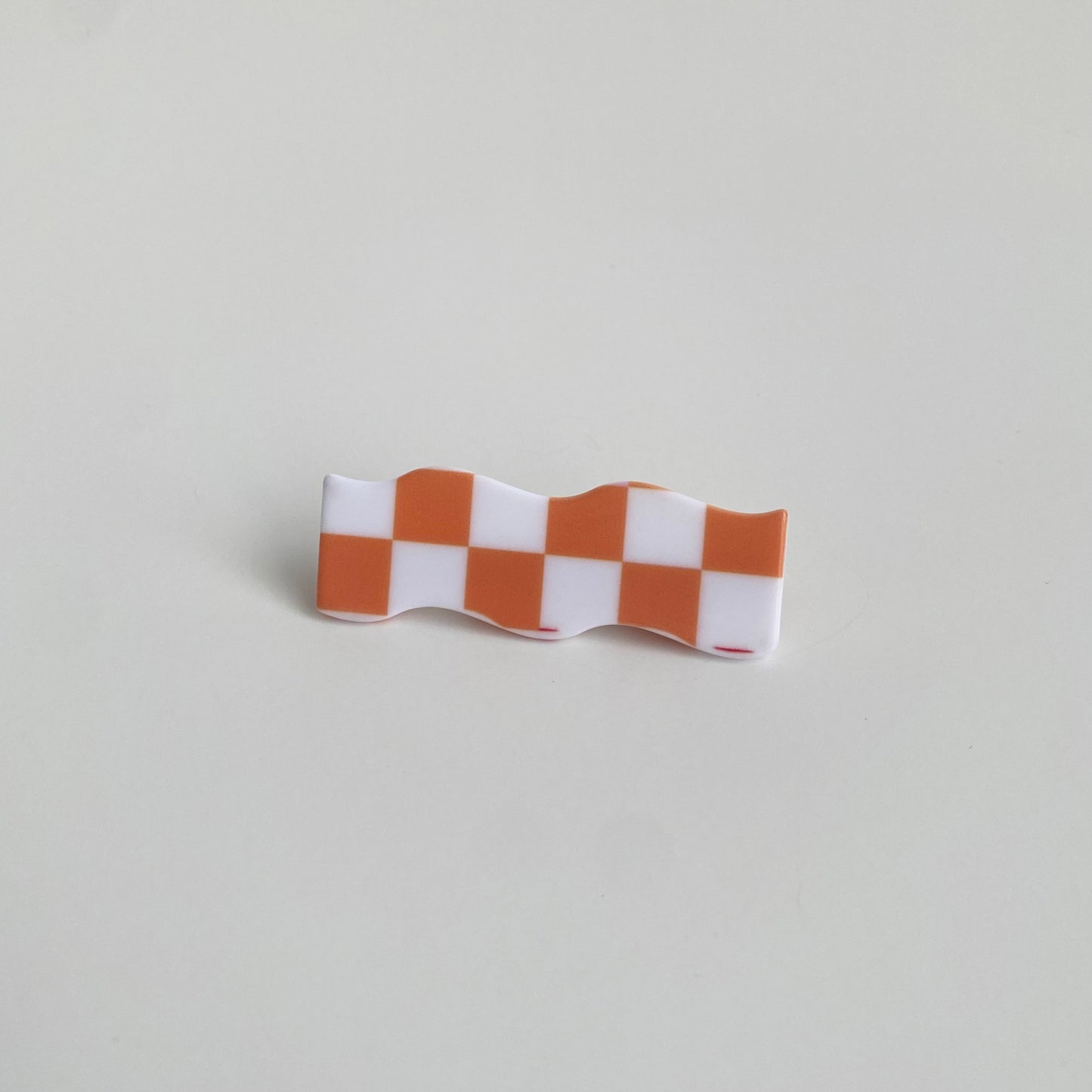 Checkered hairpin in orange checkered wave