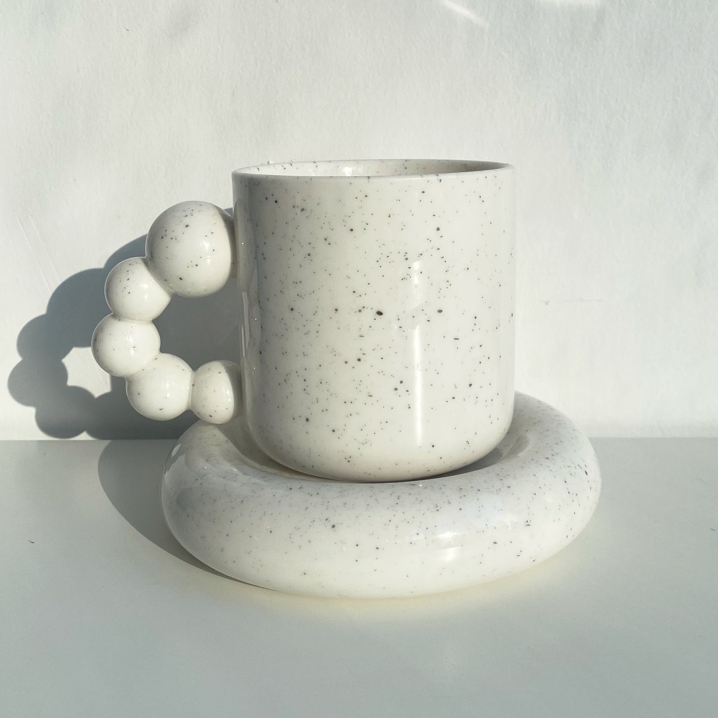 pearl handle ceramic mug in white with black speckles